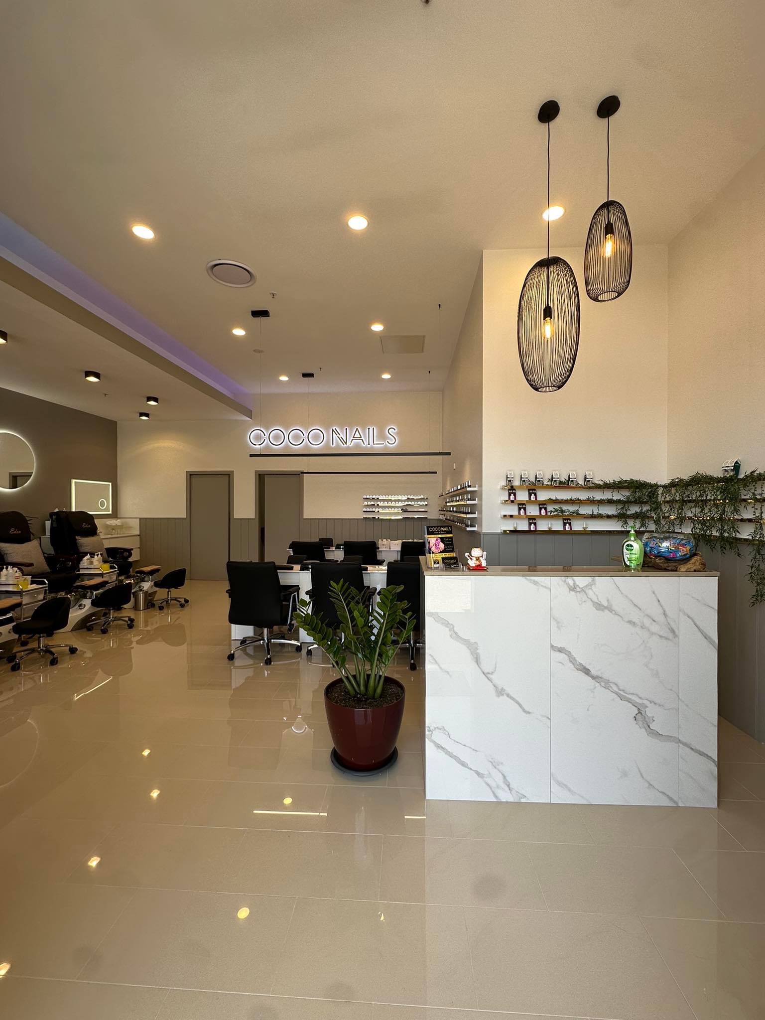 Inside CoCo Nails: reception counter, backlit COCO NAILS sign, pedicure chairs and manicure stations
