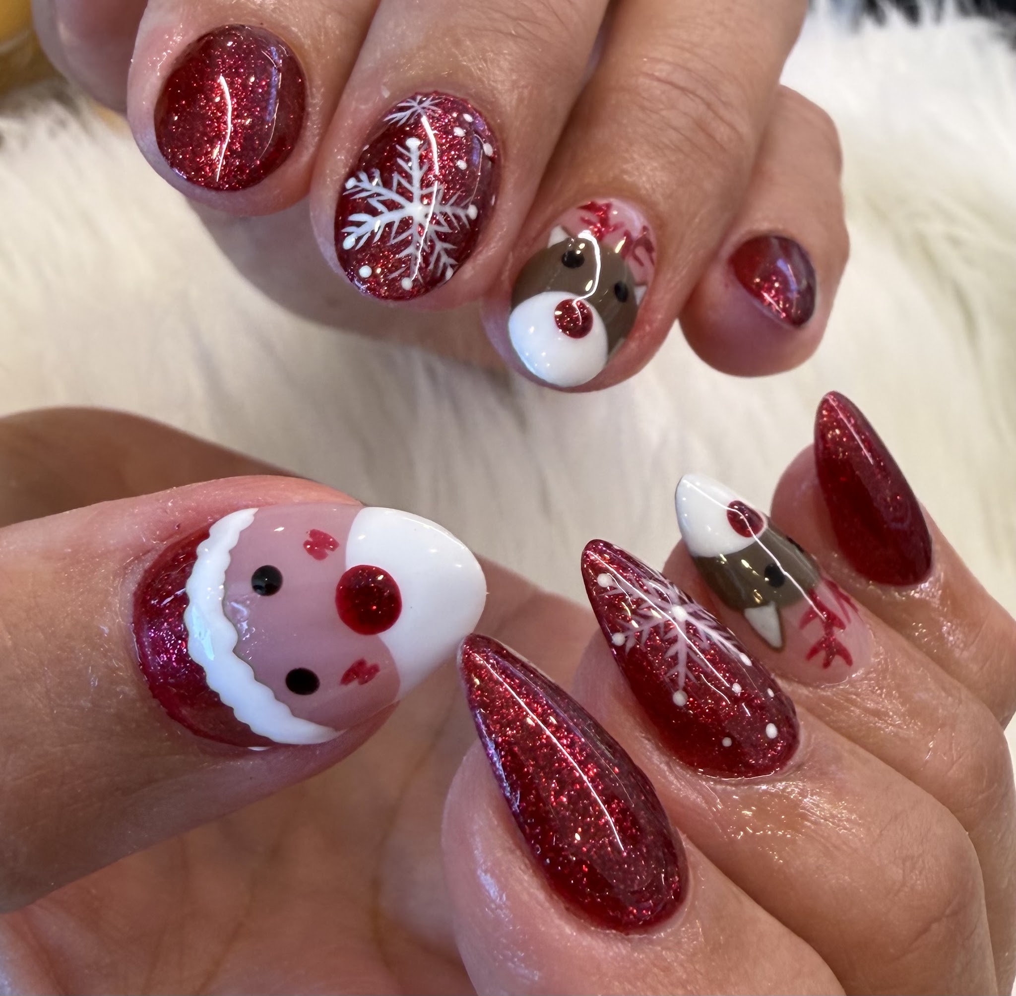 Festive red glitter nail set with snowflake and reindeer art
